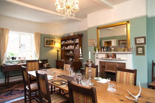 uma sala de jantar com uma mesa e um espelho em Lower Buckton Country House em Leintwardine