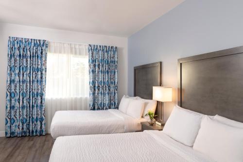 a hotel room with two beds and a window at Beachfront Inn and Suites at Dana Point in Capistrano Beach