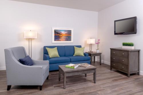 a living room with a blue couch and a tv at Beachfront Inn and Suites at Dana Point in Capistrano Beach