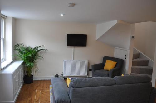 a living room with a couch and a tv at French Horn Cottage in Ware