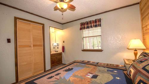 a bedroom with a bed and a ceiling fan at Whispering Pine Cabins in Ruidoso