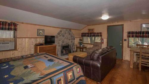 a living room with a couch and a fireplace at Whispering Pine Cabins in Ruidoso