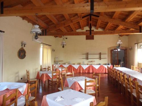 a dining room with white tables and wooden chairs at Fattoria Cerreto in Mosciano SantʼAngelo