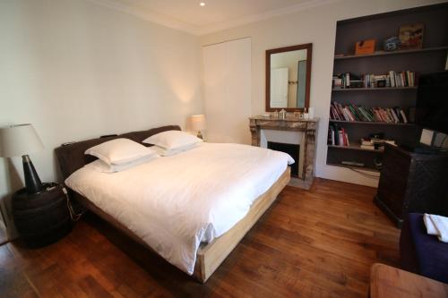 1 dormitorio con 1 cama con chimenea y espejo en Atout Charme, en Versalles