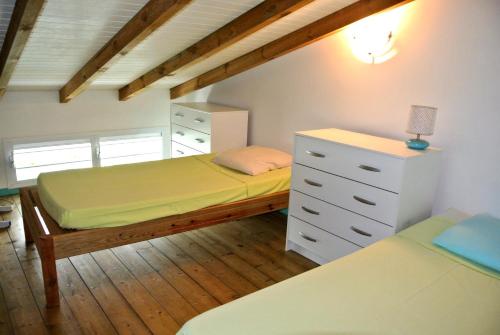a small bedroom with a bed and a dresser at Bungalows MALUEVA in Sainte-Anne