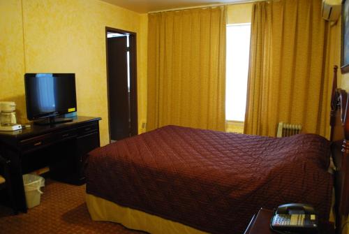 a hotel room with a bed and a television at Chinatown Hotel Chicago in Chicago