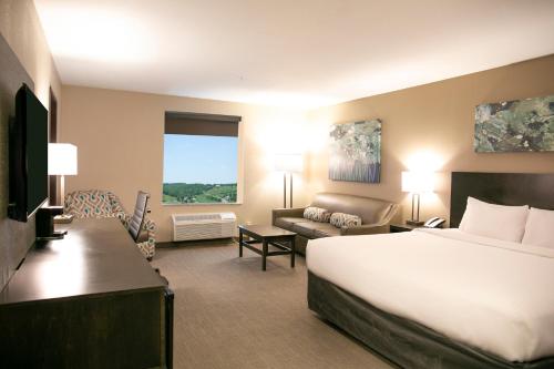 バーリンにあるBerlin Encore Hotel & Suitesの大きなベッドとソファが備わるホテルルームです。