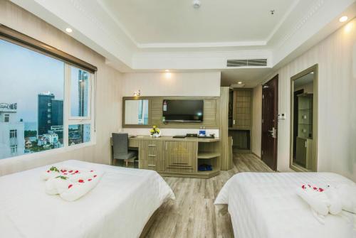 a hotel room with two beds and a television at Golden Rose Hotel in Da Nang
