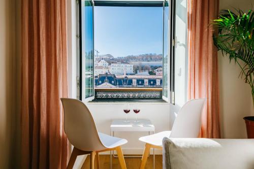 Zimmer mit einem Fenster und 2 Gläsern Wein in der Unterkunft Urban Jungle in Lissabon