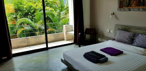 a bedroom with a bed and a large window at Sairee Sairee Guesthouse in Ko Tao