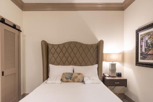 a bedroom with a large bed with a large headboard at Andrew Pinckney Inn in Charleston