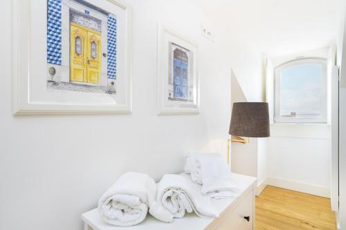 een kamer met witte muren en een tafel met handdoeken bij Velvet Dream Apartment in Lissabon