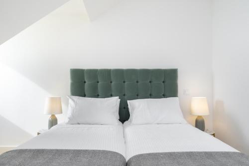 リスボンにあるVelvet Dream Apartmentのベッドルーム1室(緑のヘッドボード、白い枕2つ付)