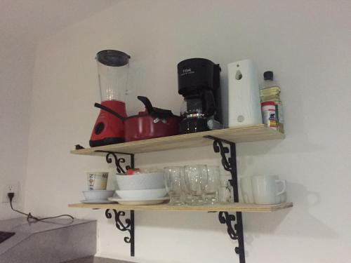 a shelf on a wall with a coffee maker and cups at Apartamento privado, NUEVO Rooftop, AC, GRAN WF in Cancún
