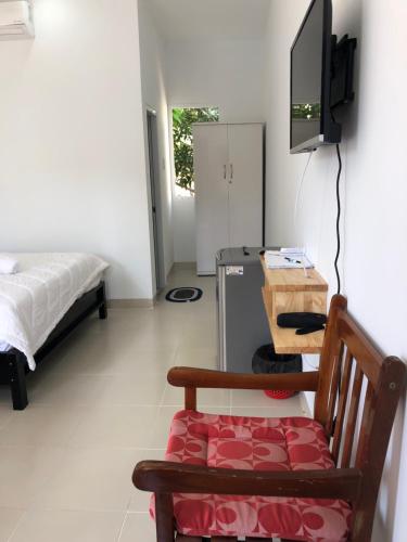 a room with a bed and a tv and a chair at Bí Homestay in Mui Ne