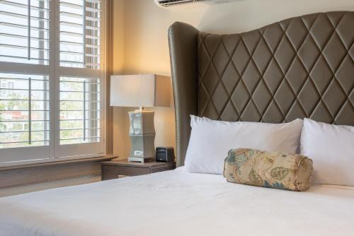 a bedroom with a bed with a large white bedspread at Andrew Pinckney Inn in Charleston