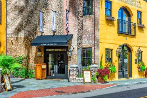 a brick building with a black awning on a street at Andrew Pinckney Inn in Charleston