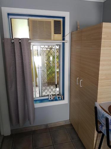 a window in a room with a curtain and a door at Limassol Motel in Gold Coast