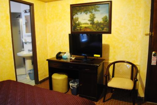 a hotel room with a television on a table with a chair at Chinatown Hotel Chicago in Chicago