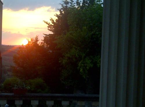 a sunset seen from a window with a tree at B&B A Casa di Mael in San Costanzo