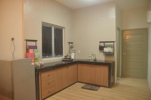 a kitchen with a counter top and a refrigerator at Plumber house in Tanah Rata