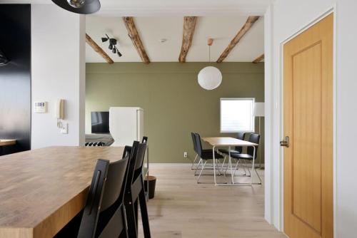 a dining room with a large wooden table and chairs at Vacation House Tennoji 168 IROHA, Osaka in Osaka