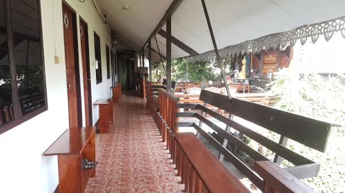 a row of wooden benches in a building at Boondee House in Mae Hong Son