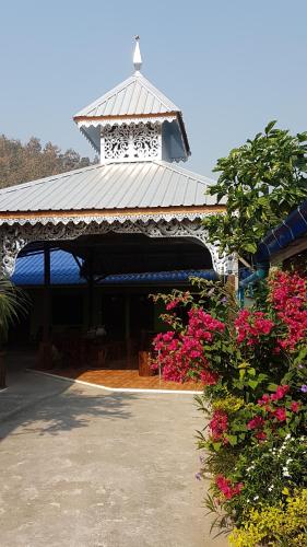 a pavilion with a white roof with pink flowers at Boondee House in Mae Hong Son