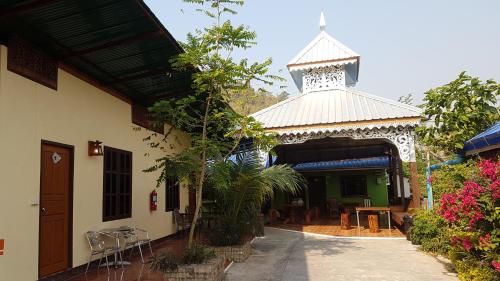 a building with a pavilion with a table and chairs at Boondee House in Mae Hong Son