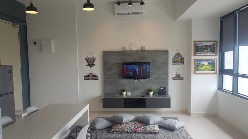 a living room with a tv on a wall at D'Kroll Tamarind Cyberjaya 1 Bedroom Premium Suite with Netflix in Cyberjaya
