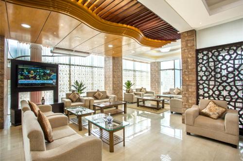 a lobby with couches and a flat screen tv at White Palace Hotel in Dhaka