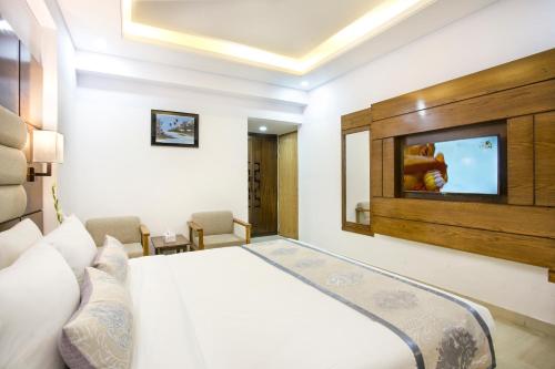 a hotel room with a bed and a flat screen tv at White Palace Hotel in Dhaka