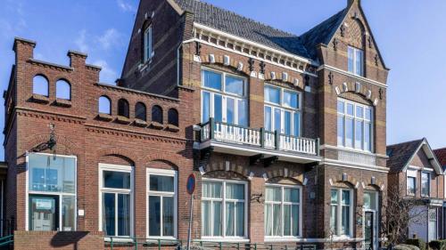 a large brick building with a balcony on it at B&B Het Oude Postkantoor in Yerseke