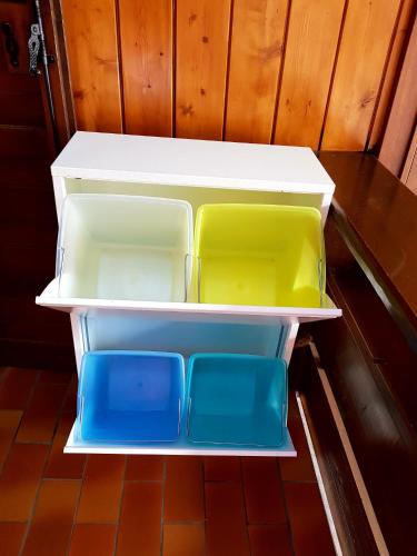 an empty refrigerator with four different colored containers in it at Residence La Zondra in Pozza di Fassa