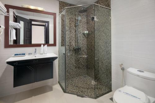 a bathroom with a shower with a toilet and a sink at Serene Boutique Hotel & Spa in Hanoi