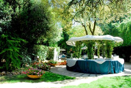 a table with an umbrella in a garden at Park Hotel San Michele in Martina Franca