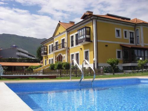 a swimming pool with a slide in front of a building at Hotel Finca La Mansión in Llanes