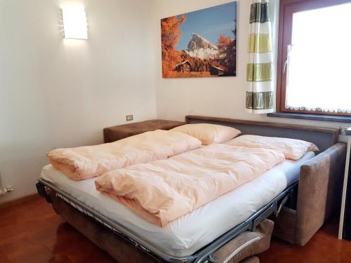 two beds in a room with a window at Residence La Zondra in Pozza di Fassa