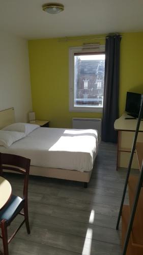 a bedroom with a bed and a desk and a window at Résidence Hôtelière Poincaré in Margny-lès-Compiègne
