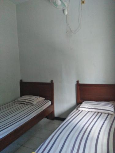 Postel nebo postele na pokoji v ubytování Penginapan Hotel Mangir Asri