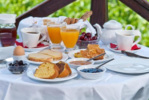a table topped with plates of breakfast foods and drinks at Iliovolo Guesthouse in Miléai