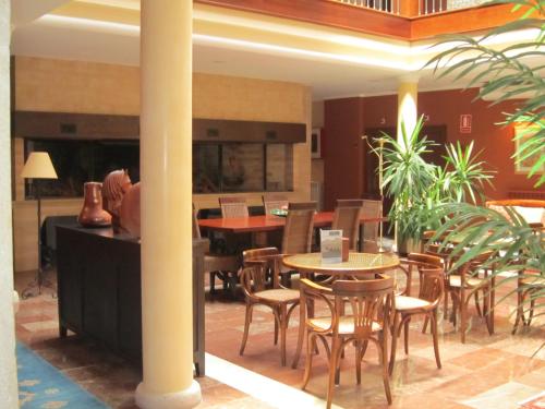 a restaurant with tables and chairs in a lobby at Hotel Finca La Mansión in Llanes