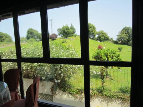a view of a field from a window at Hotel Finca La Mansión in Llanes