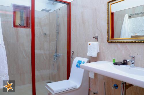 a bathroom with a shower and a sink and a mirror at RJ Mahaal Hotel in Kilinochchi