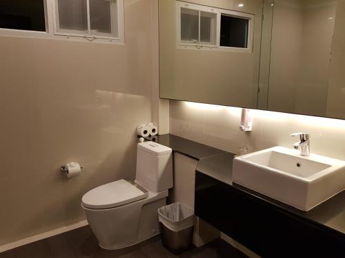 a bathroom with a toilet and a sink and a mirror at Ayara Villas - SHA Extra Plus in Khao Lak
