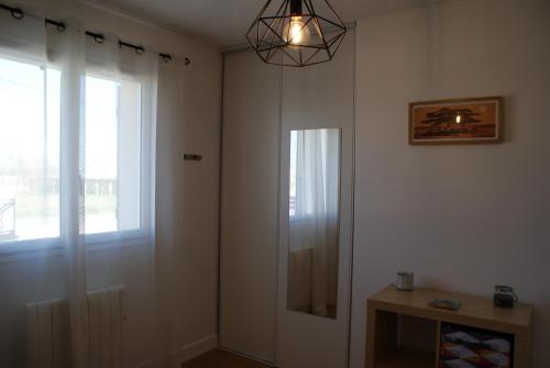 um quarto com uma porta, uma janela e um candeeiro em MARIBEN em Pujols Gironde
