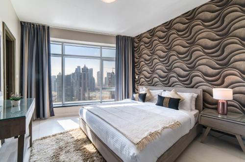 a bedroom with a large bed and a large window at Icon Casa Living - Super Loft West Tower in Dubai