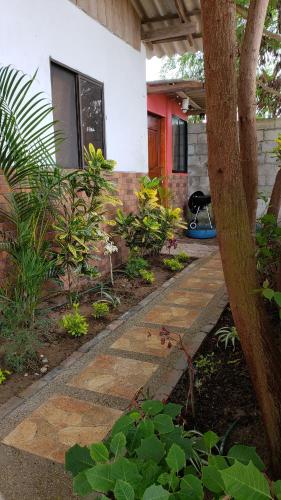 a garden with a stone walkway in front of a house at Hugo's relax home (Suite) in Ayangue