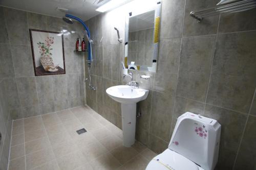 a bathroom with a toilet and a sink at Jeonju Hotel in Jeonju