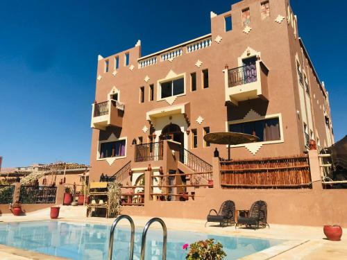 a building with a swimming pool in front of a building at Riad Dar Bab Todra in Tinerhir